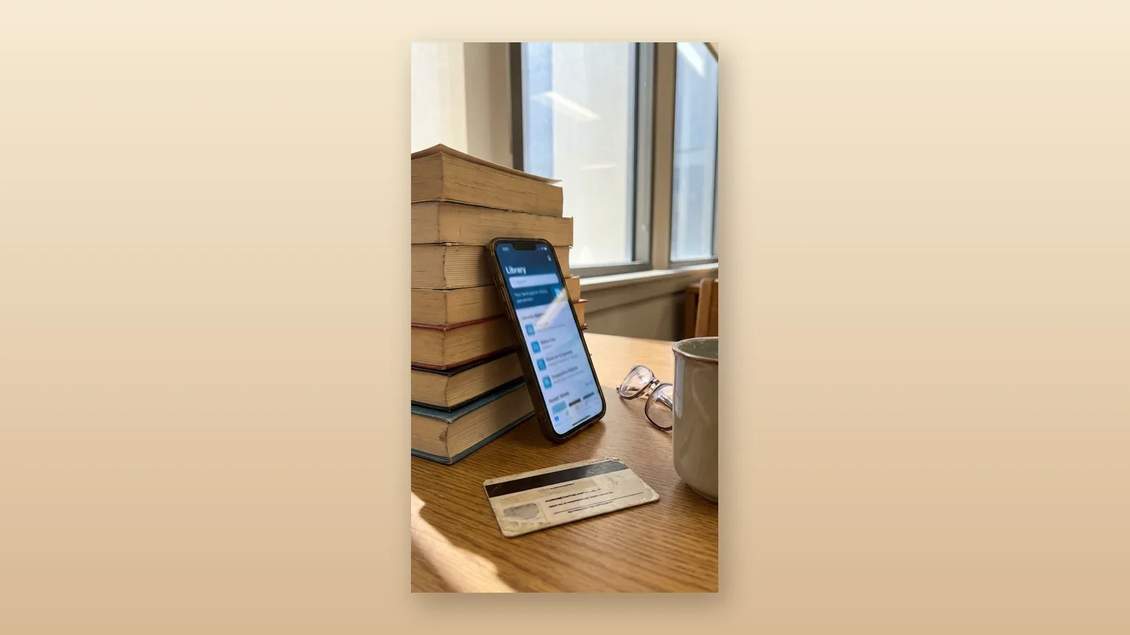 A phone open to a Libby shelf of borrowed books, set on a warm reading table